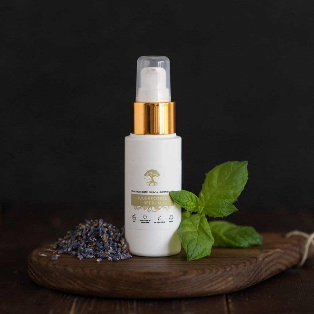 2. HOIA homespa hair serum for split ends, 50ml bottle with gold cap, displayed with lavender and mint on a wooden board