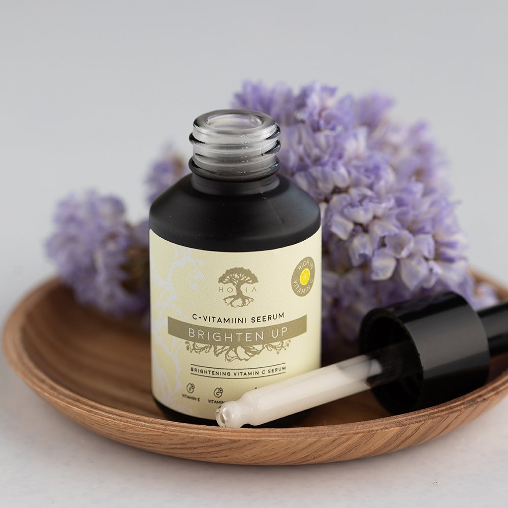 2. Open HOIA homespa Brightening Vitamin C Serum bottle with dropper, shown on a wooden tray with purple flowers