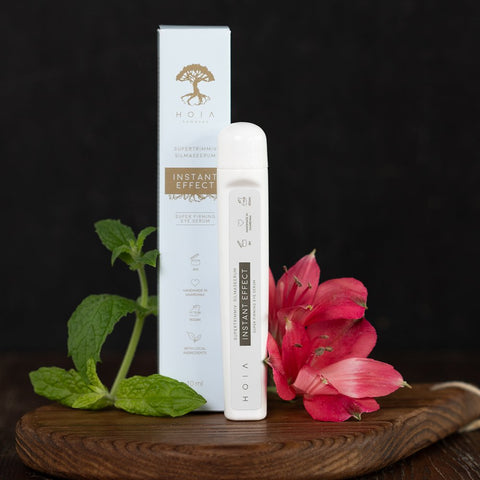 2. HOIA homespa Superfirming Eye Serum Instant Effect 10ml with packaging and pink flower on wooden surface