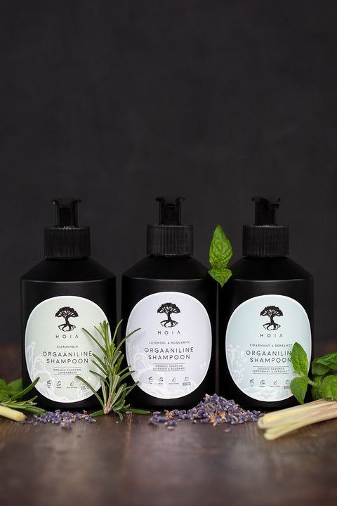 2. Trio of HOIA homespa Organic Shampoos including Peppermint & Bergamot, displayed with herbs and lavender