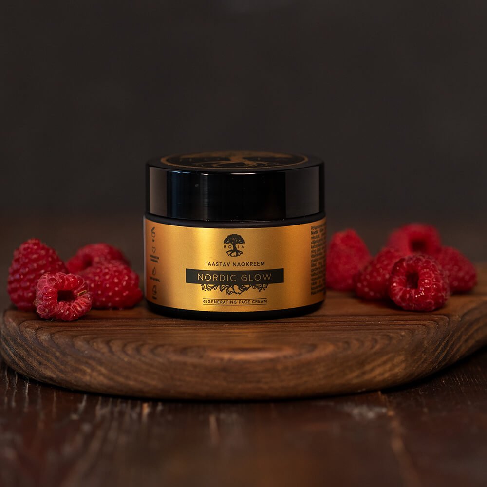 2. HOIA homespa Nordic Glow face cream jar on wooden board with raspberries, emphasizing natural skincare