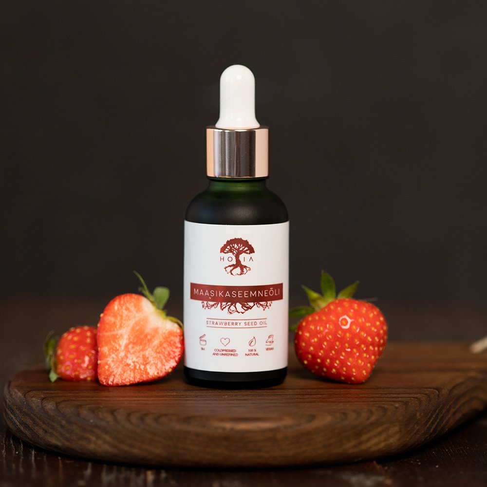 2. HOIA homespa Strawberry Seed Oil bottle with fresh strawberries on wooden board, studio setting