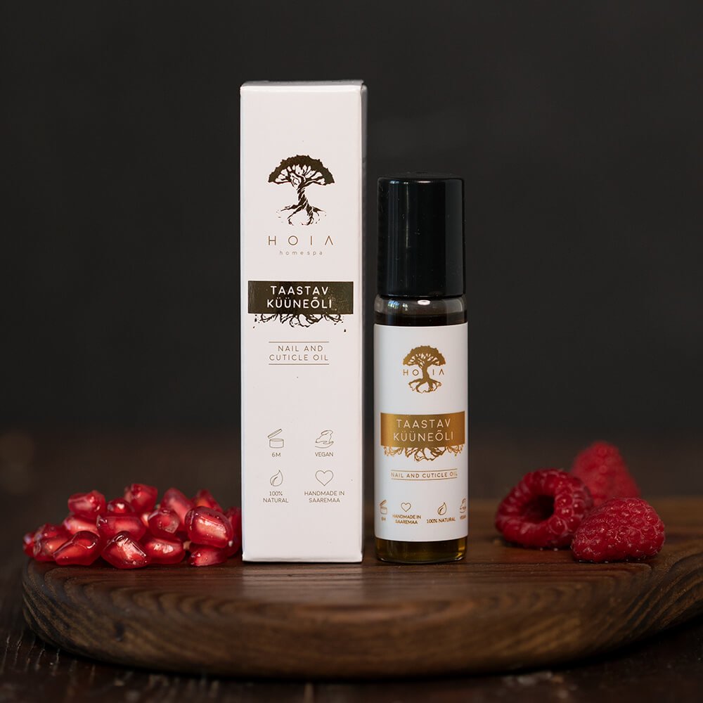 1. HOIA homespa Restorative Nail Oil 15ml with roller applicator, shown with packaging and fresh raspberries and pomegranate seeds, highlighting natural ingredients and vegan formula