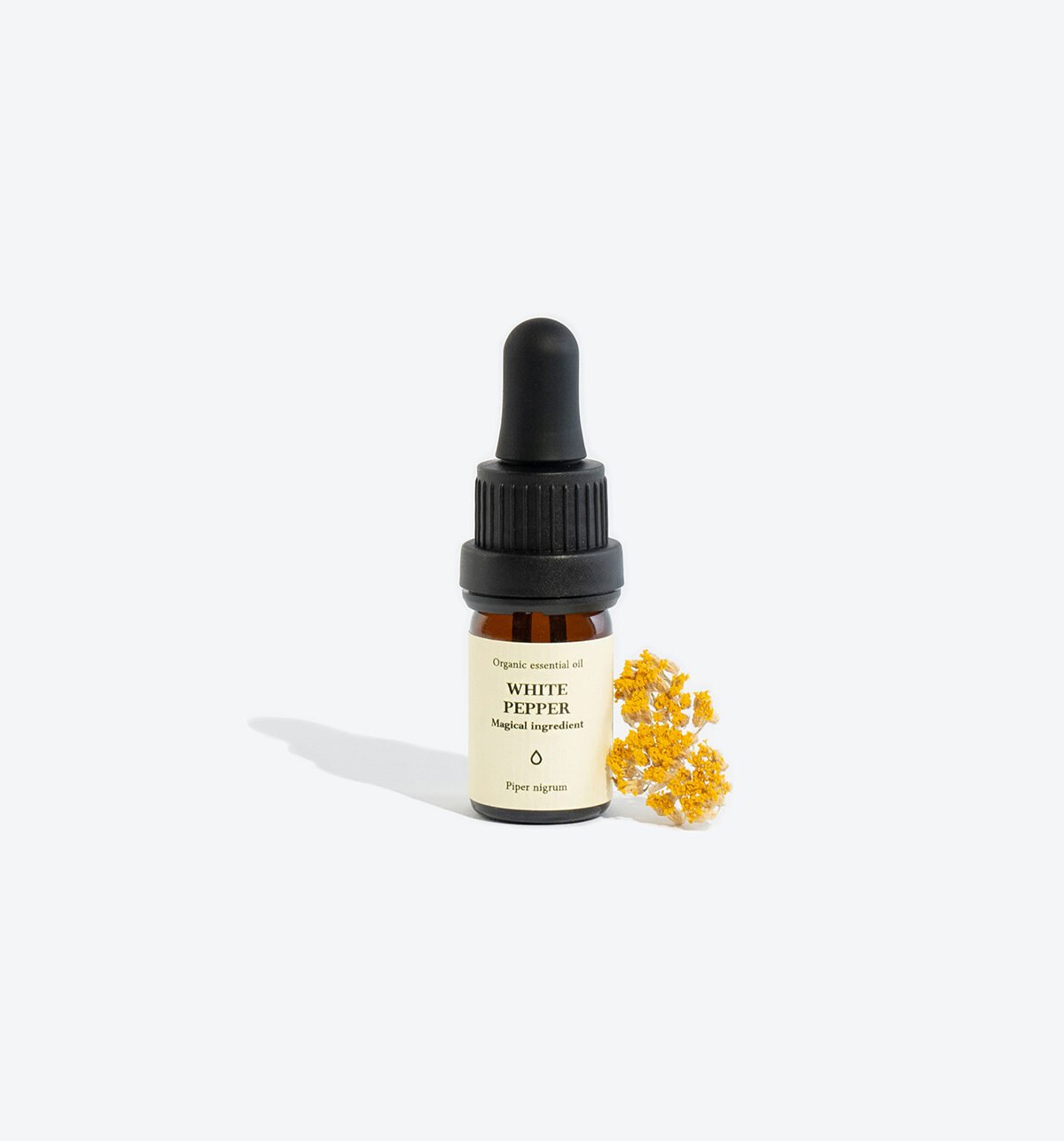 1. Smells Like Spells WHITE PEPPER essential oil in 5 ml glass bottle with pipette, shown with yellow flowers
