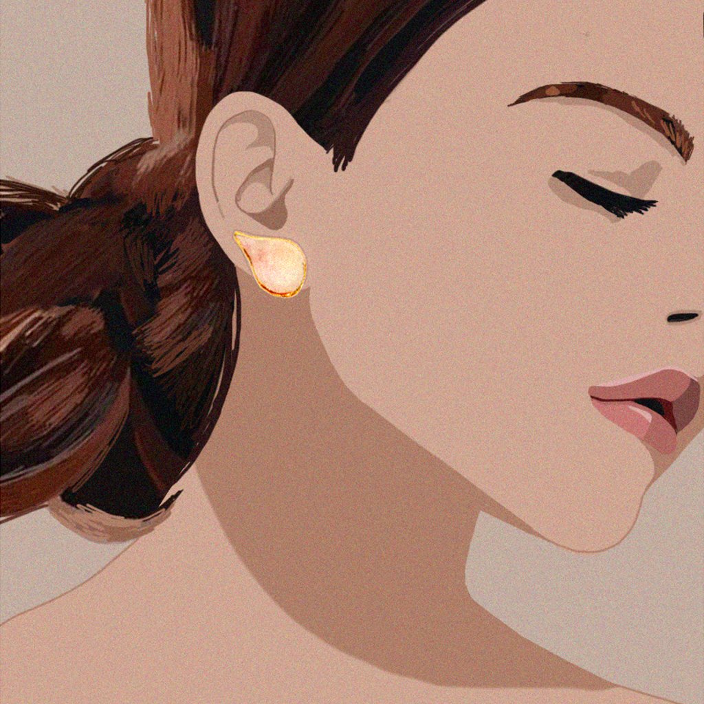 1. Woman wearing SCULP Wild Cherry Leaf STUD earrings with 24K gold details, shown in lifestyle setting