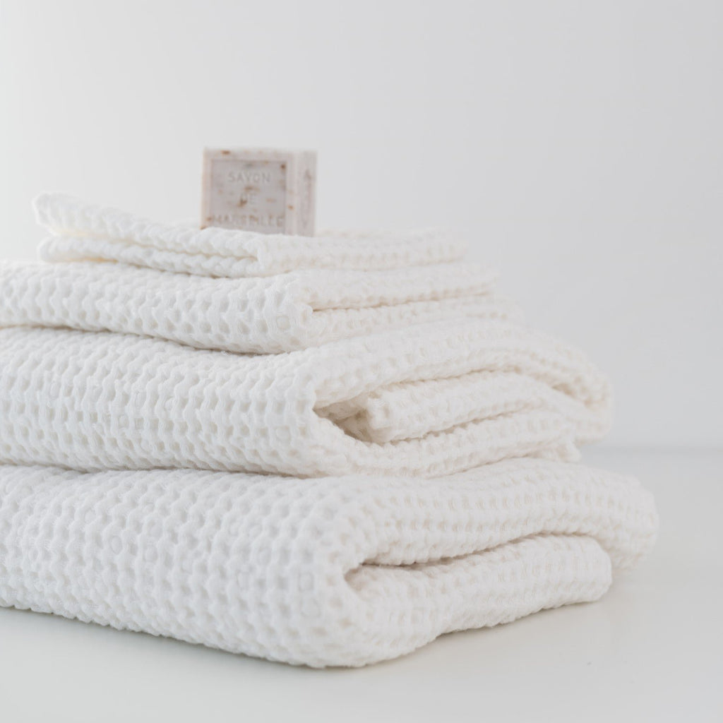 2. Stack of white honeycomb waffle towels with soap bar, showcasing texture and volume