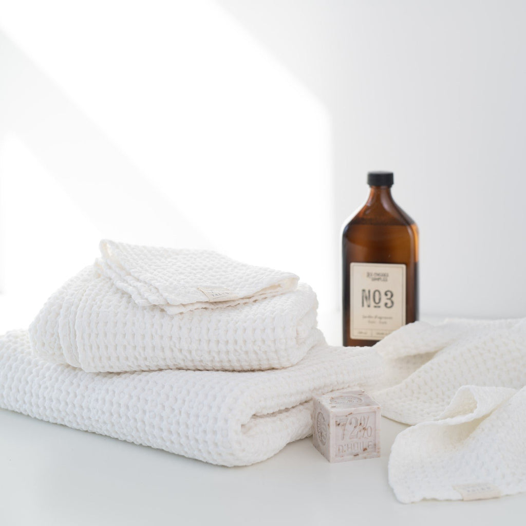 1. White honeycomb waffle towels with amber bottle and soap, showcasing spa-like setting