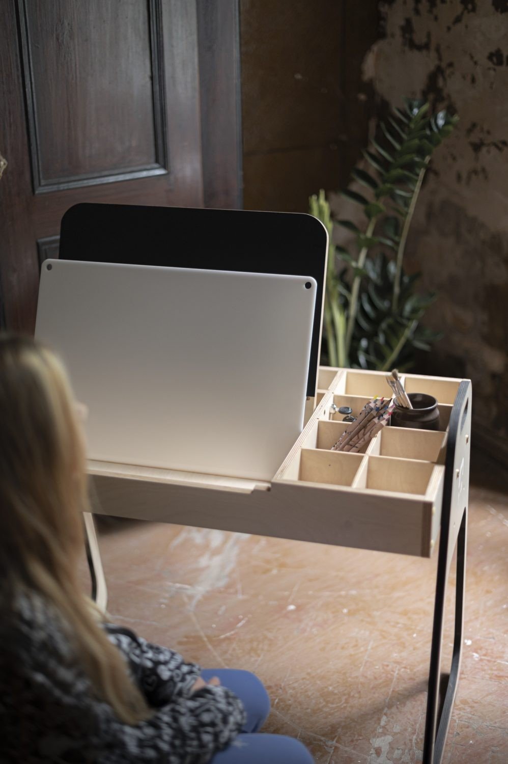 5. Child sitting at desk with LUULA acrylic whiteboard and storage compartments