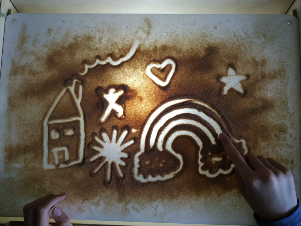 8. Child drawing on LUULA acrylic whiteboard with sand art