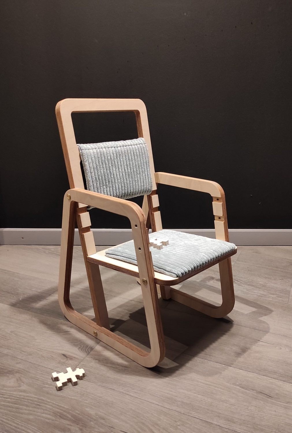 2. Mint green cushioned chair with armrests on wooden floor