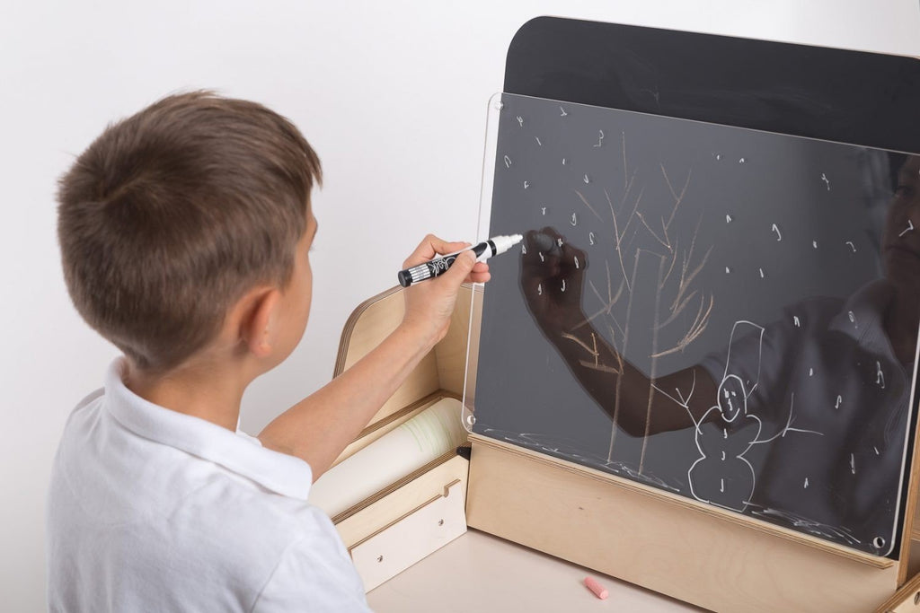 17. Child drawing on Luula Julle table with paper roll and storage, promoting creativity