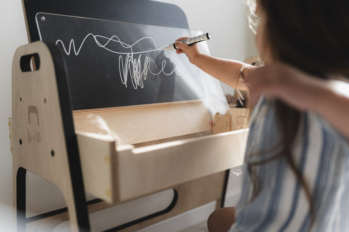3. Close-up of boy drawing on acrylic board at Montessori table
