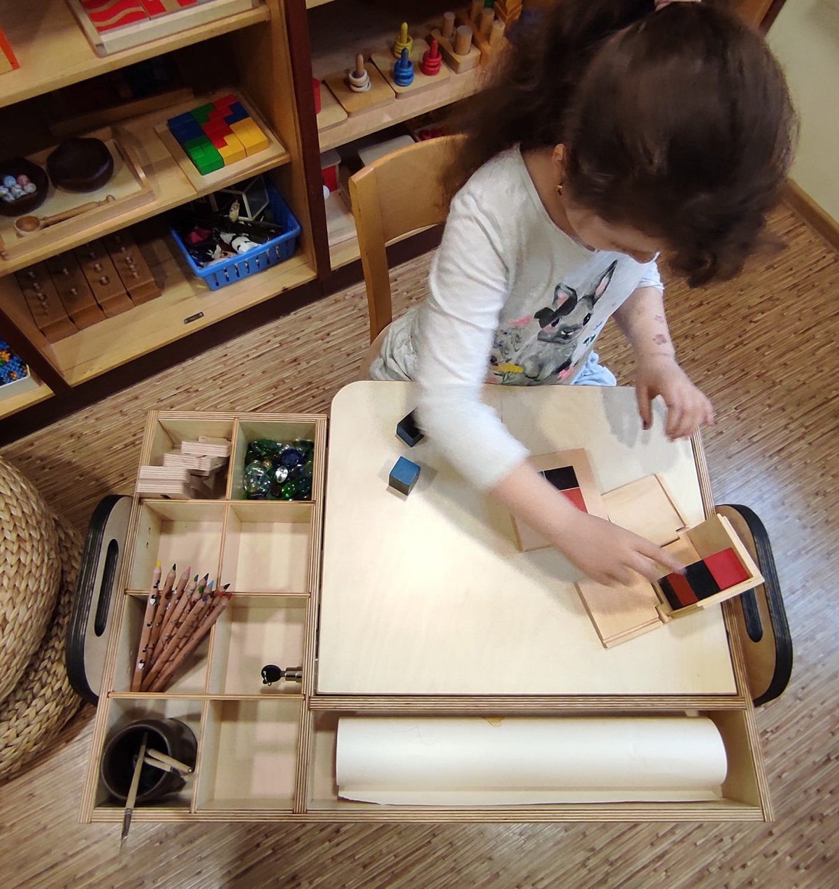 1. Girl using Montessori table with chalkboard in a bright room