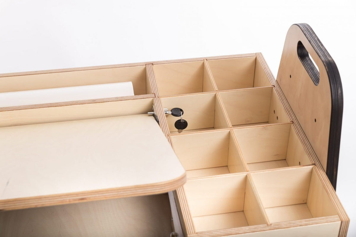 10. Child using Luula Julle table for creative activities, highlighting storage and paper roll