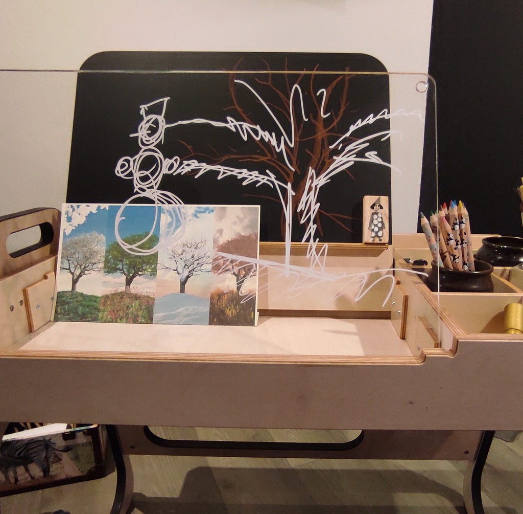 3. Close-up of Luula Montessori table with acrylic board and art supplies, showcasing creative drawing space