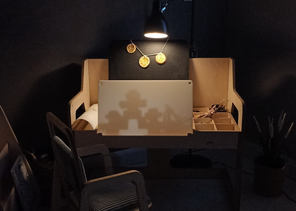 1. Luula Montessori table set in dimly lit room with lamp, showcasing cozy learning environment