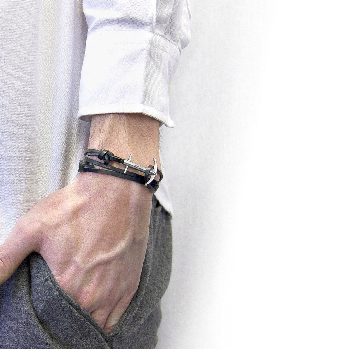 1. Men's Coal Black Admiral Anchor Silver and Flat Leather Bracelet by ANCHOR & CREW, worn with white shirt and grey pants