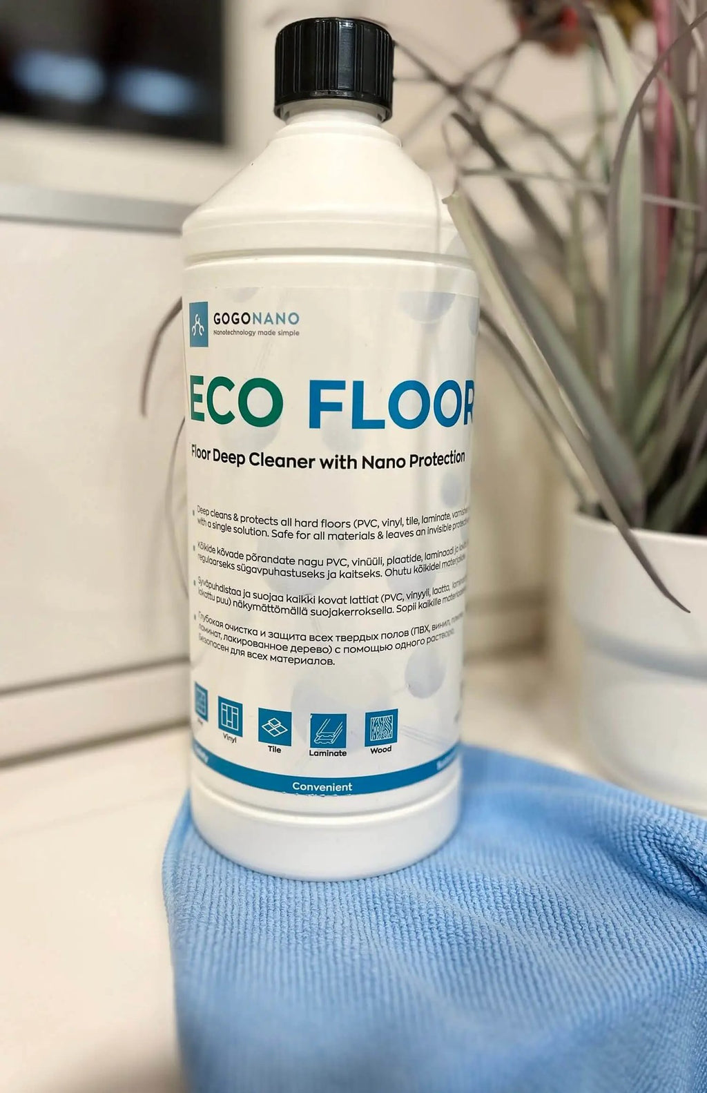 4. GoGoNano EcoFloor natural floor cleaner 1L bottle on a blue cloth near a plant