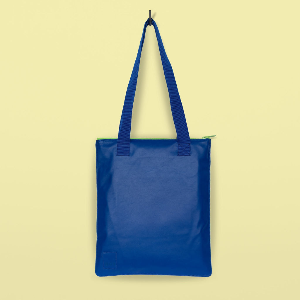 4. Studio shot of Daz Studio handmade leather tote in royal blue with blue nylon straps and neon green zipper