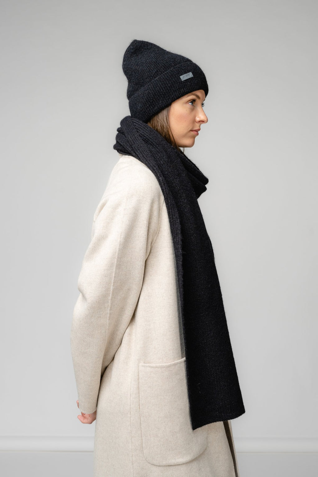 5. Women's black Alpaka Fisherman's Rib scarf and hat shown from side in studio