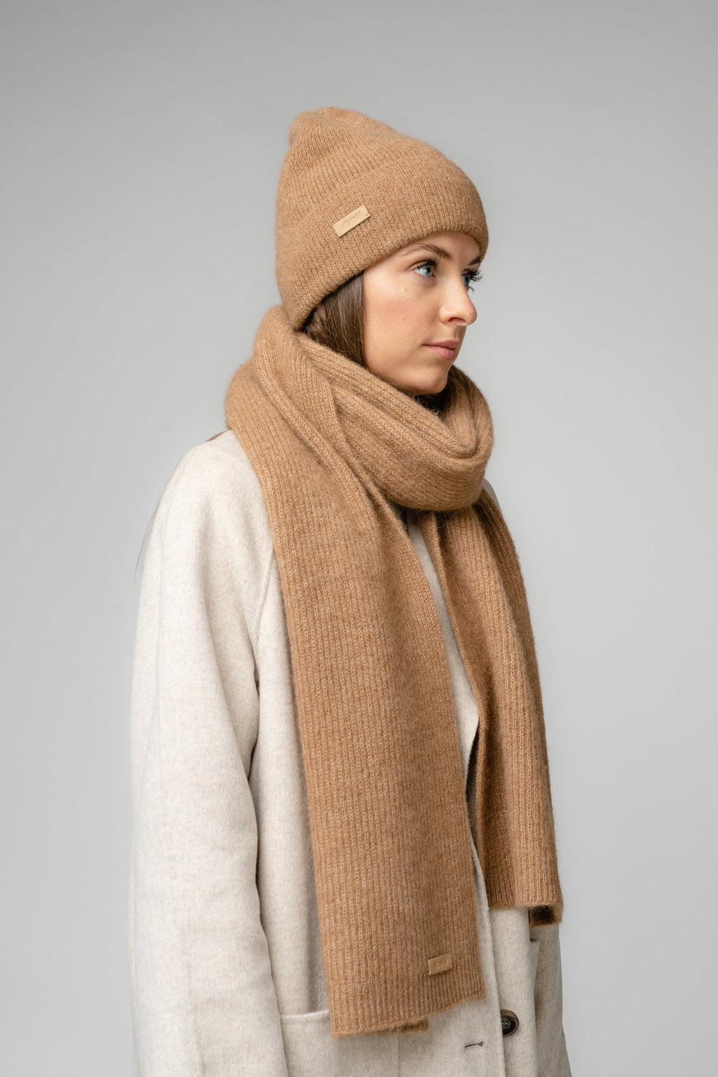 23. Women's camel Alpaka Fisherman's Rib scarf and hat set in studio setting