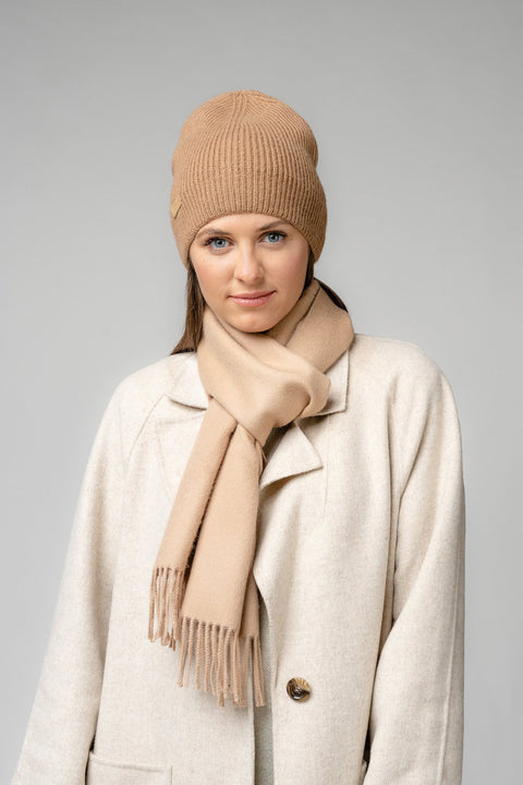 1. Woman wearing beige Alpaka baby alpaca wool scarf and matching hat in studio setting