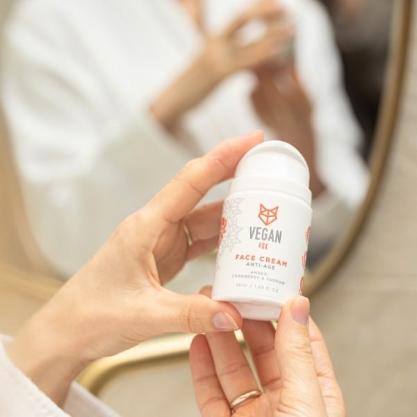 2. Woman applying Vegan Fox Anti-Age Face Cream 50ml in front of mirror
