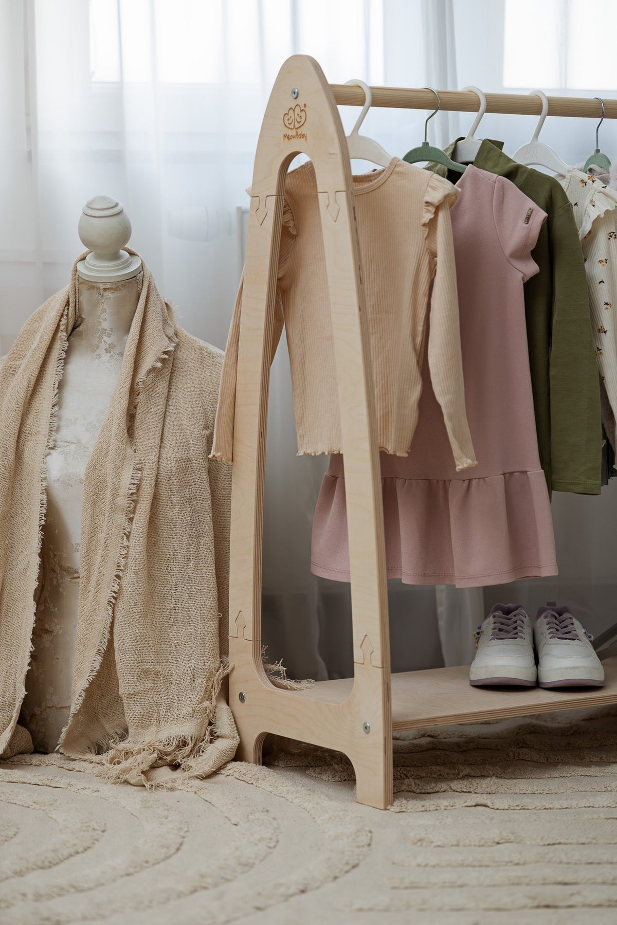 1. Children's natural wood clothing rack with clothes and shoes in cozy room setting