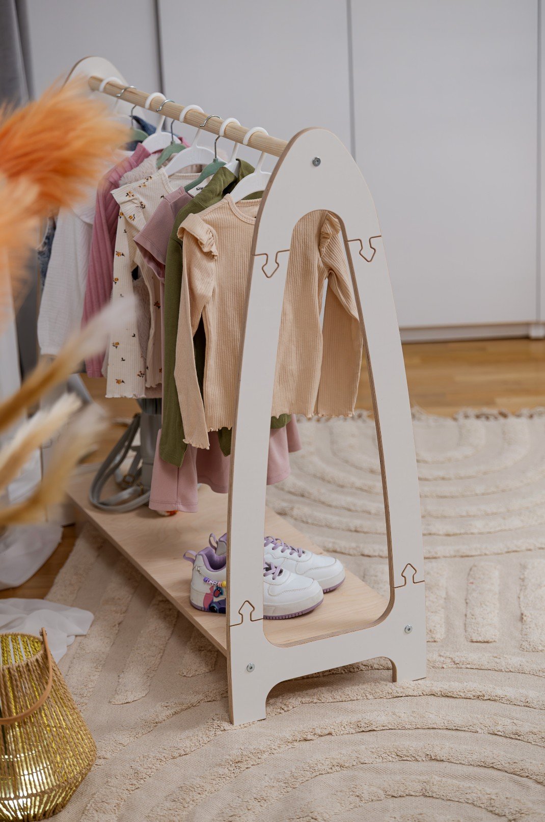 1. MeowBaby white arched clothing rack for children with clothes and sneakers, displayed in a stylish room