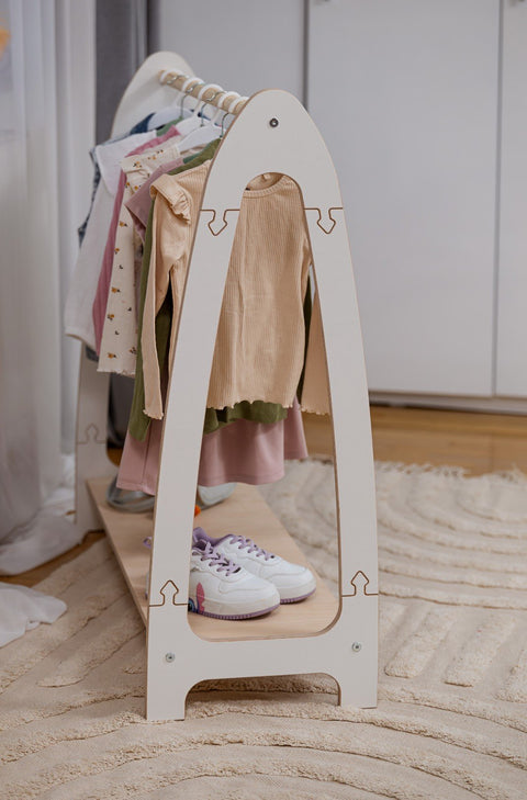 1. Children's white arched clothing rack with various clothes and shoes, placed in a cozy room setting