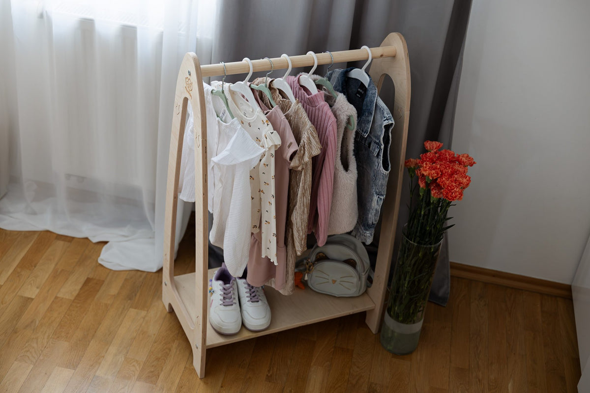 1. MeowBaby arched clothing rack in children's room with clothes, shoes, and flowers