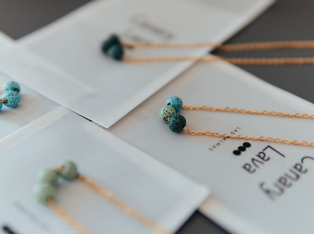 5. Aroma diffuser necklace with turquoise lava beads on silver chain, shown on Canary Lava packaging