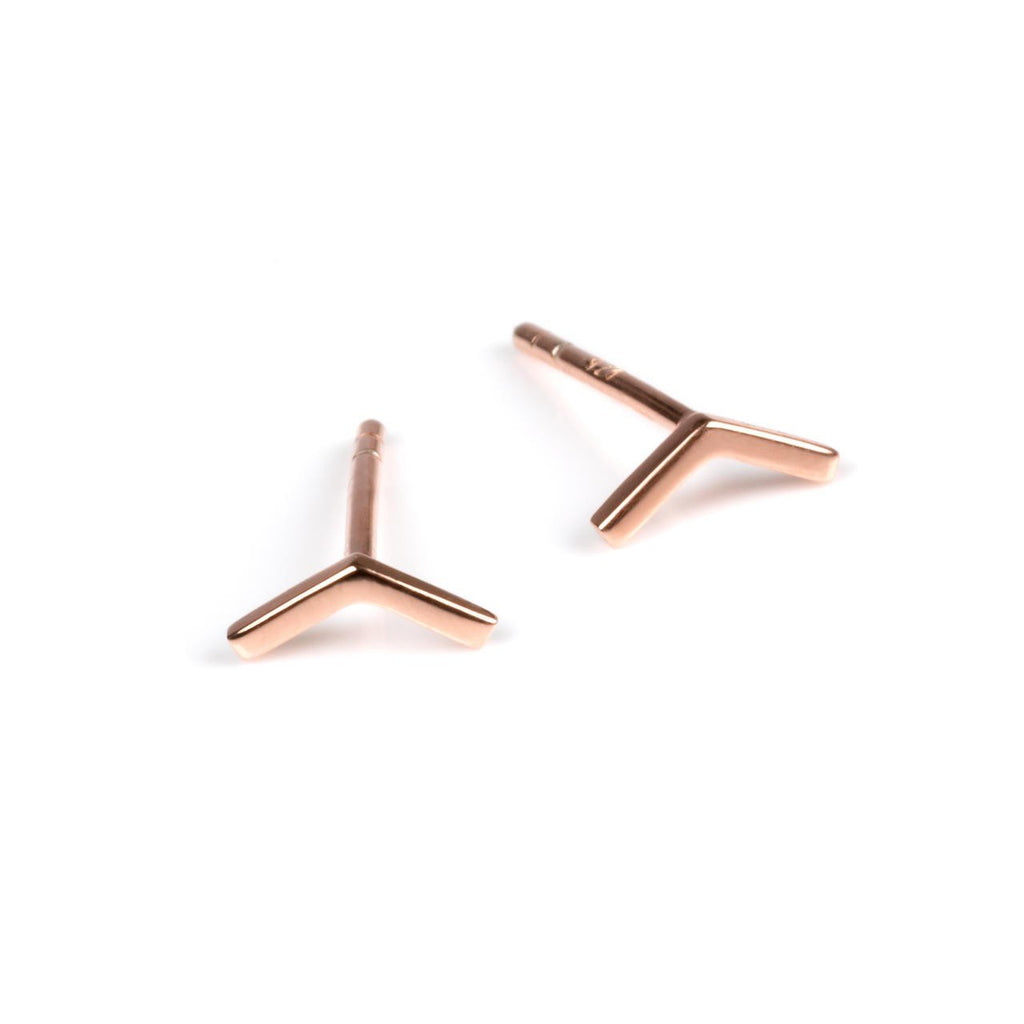2. Pair of small rose gold arrow earrings on a white background