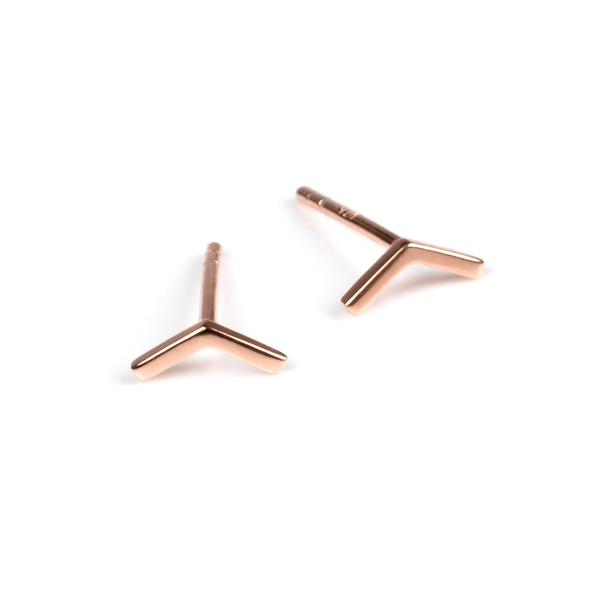 2. Pair of small rose gold arrow earrings on a white background