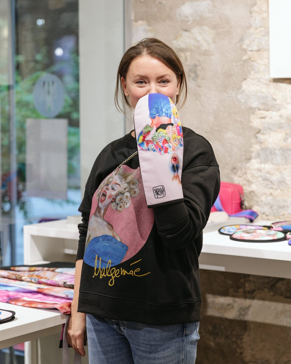 1. Woman displaying Katrin Valgemäe oven glove with pop art design in a retail environment