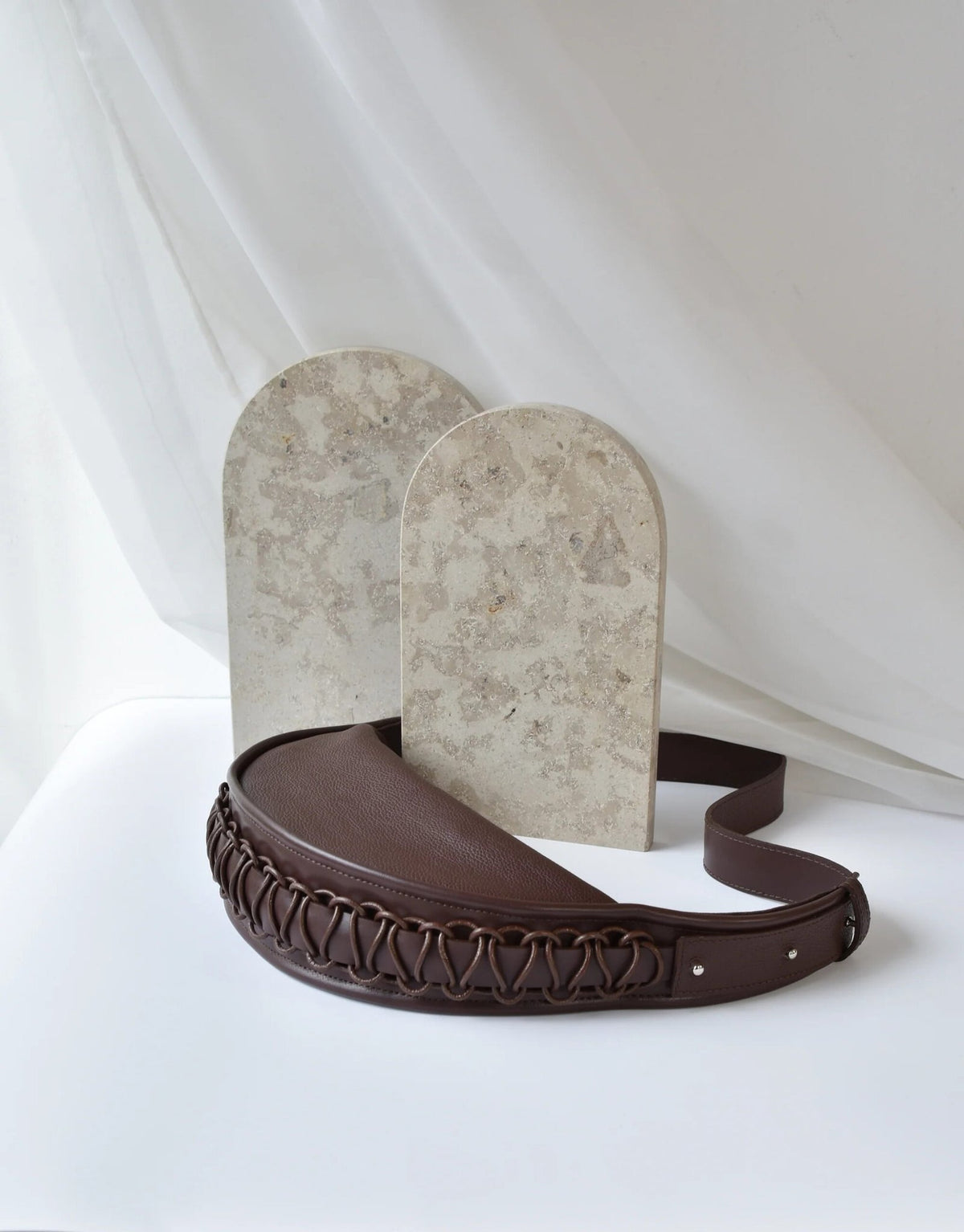 5. Studio shot of Gerda Retter Design Leather Bag Ateena in dark brown, with decorative background