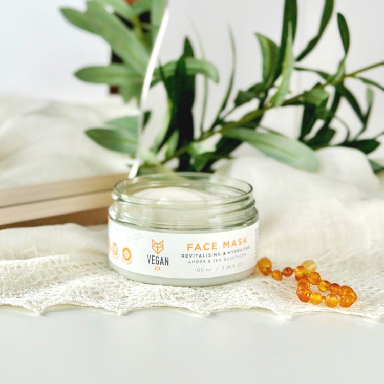 2. Woman applying Vegan Fox Revitalising & Hydrating Face Mask in a bath, holding 100 ml jar