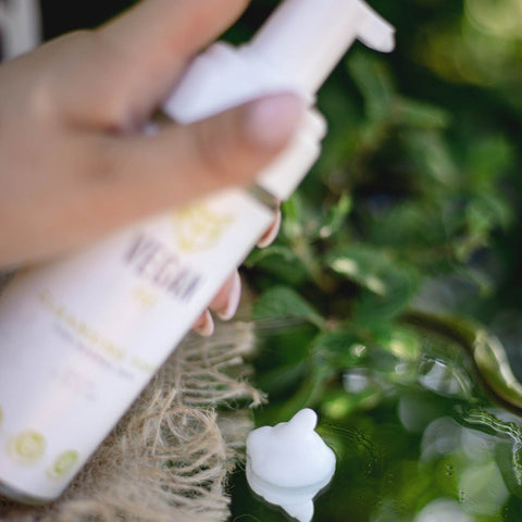 5. Close-up of Vegan Fox Cleansing Foam being dispensed, with natural greenery background