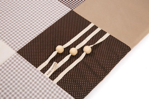 3. Close-up of wooden buttons and striped ribbons on Karloova brown activity mat
