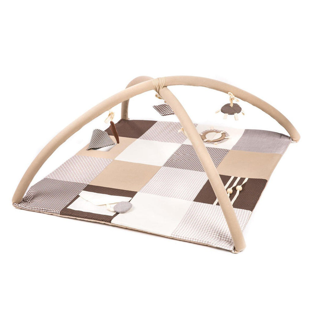 1. Baby lying on Karloova brown activity mat with arches and hanging toys in a living room setting