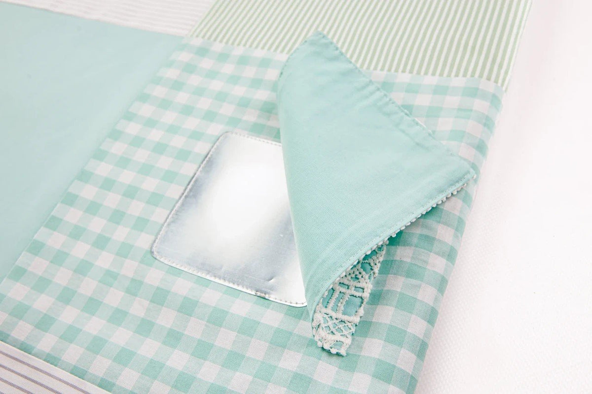 4. Close-up of mint green gingham fabric with attached mirror on baby activity mat