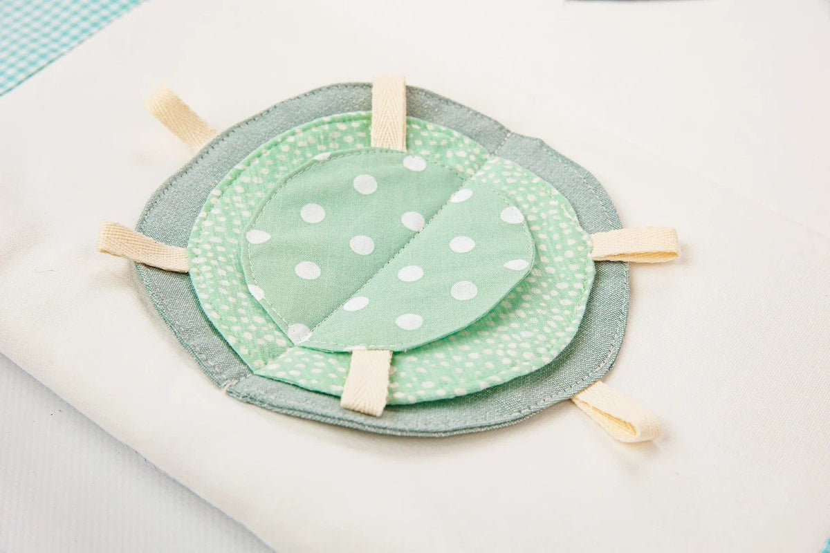 3. Close-up of mint green polka dot fabric detail on baby activity mat