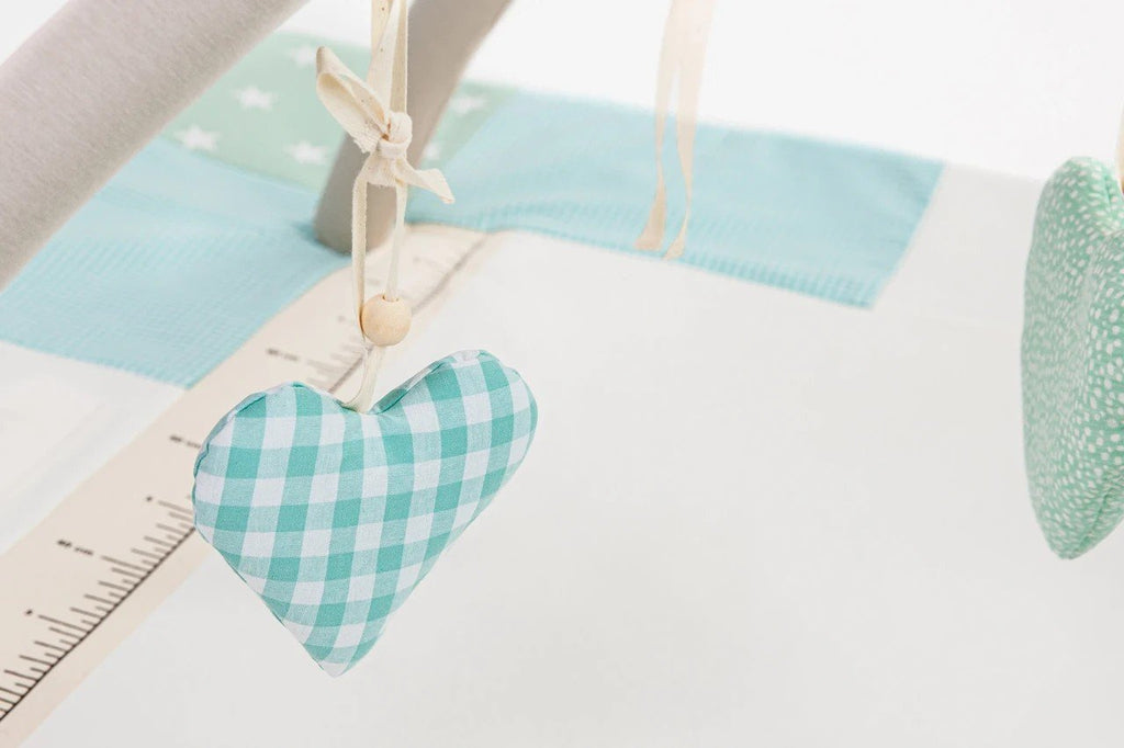 3. Close-up of hanging heart-shaped toy on baby activity mat