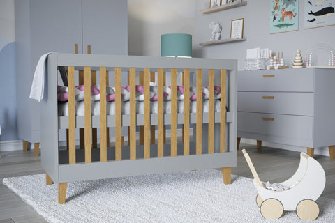 1. Close-up of grey baby cot with oak slats in stylish nursery, featuring toys and decor