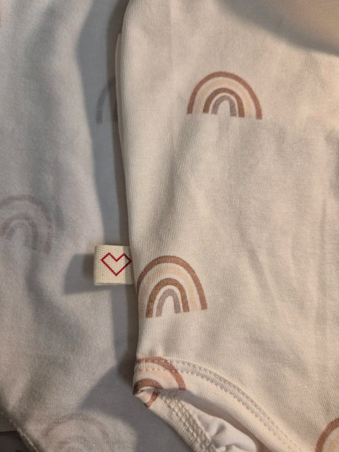 3. Close-up of Karloova rainbow print on organic cotton fabric with brand tag detail