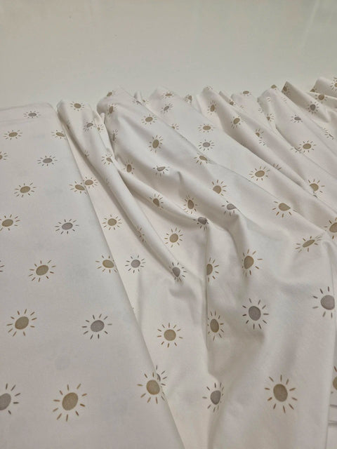 3. Close-up of Karloova baby bodysuit fabric with sun pattern highlighting texture and print