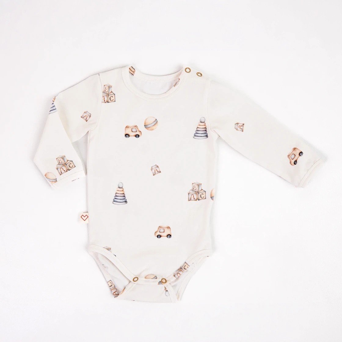 1. Baby bodysuit with toy print, featuring cars and blocks, made from organic cotton with snap buttons, laid flat on white background