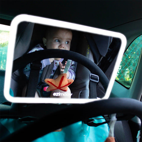 3. Baby in car seat reflected in Ezimoov LED car mirror with soft lighting in dim car interior