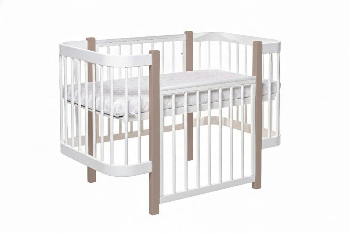 2. Studio shot of KOTTO ELIN baby crib in cappuccino and white with mattress, showing slatted sides and rounded edges