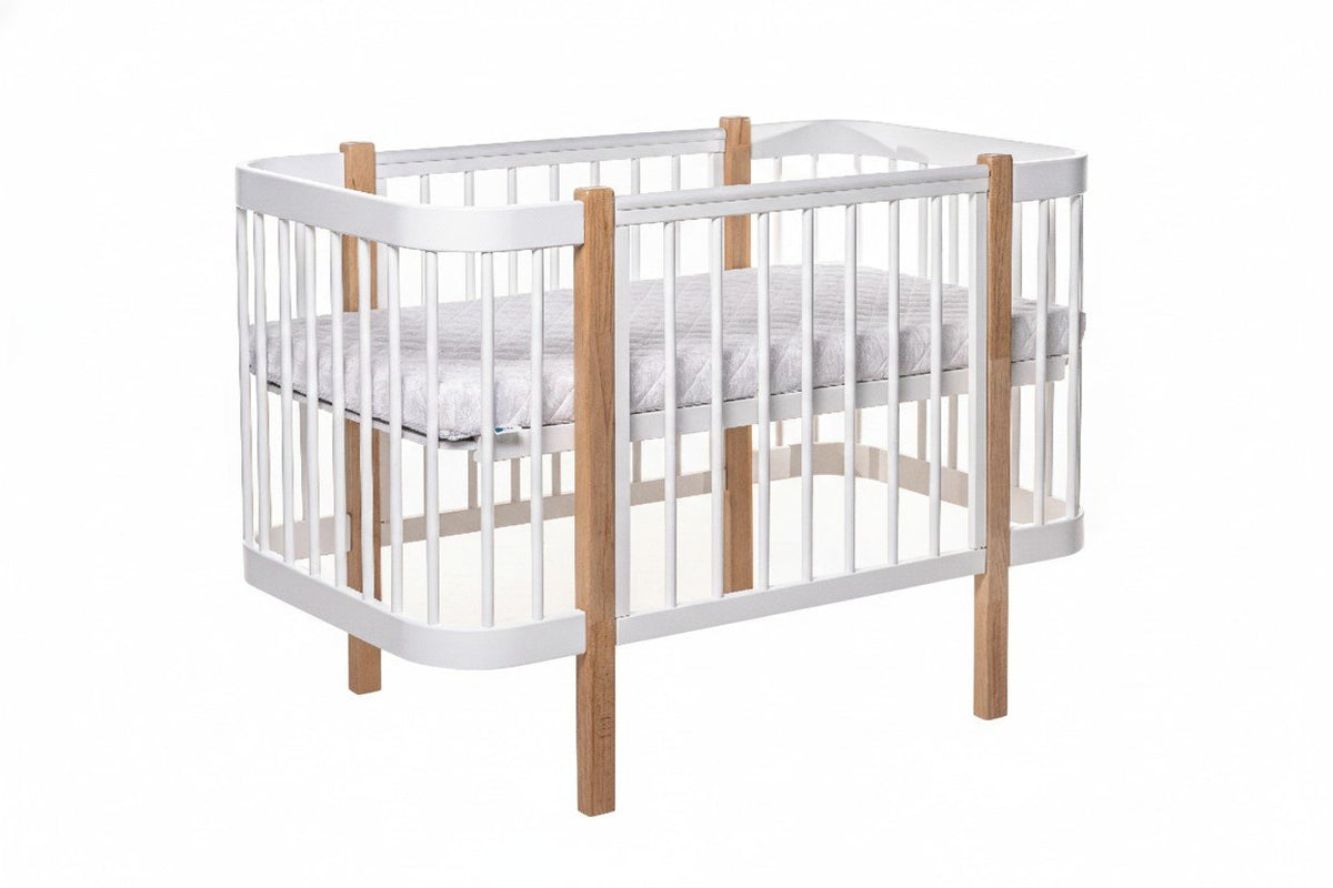 2. KOTTO ELIN baby crib in natural and white beechwood with orthopedic slatted base, shown in studio setting